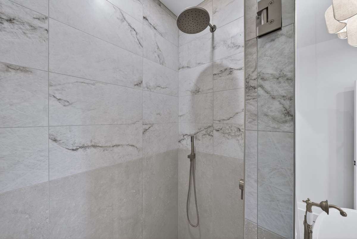 Beautifully tiled zero-entry walk-in shower in the primary bath.