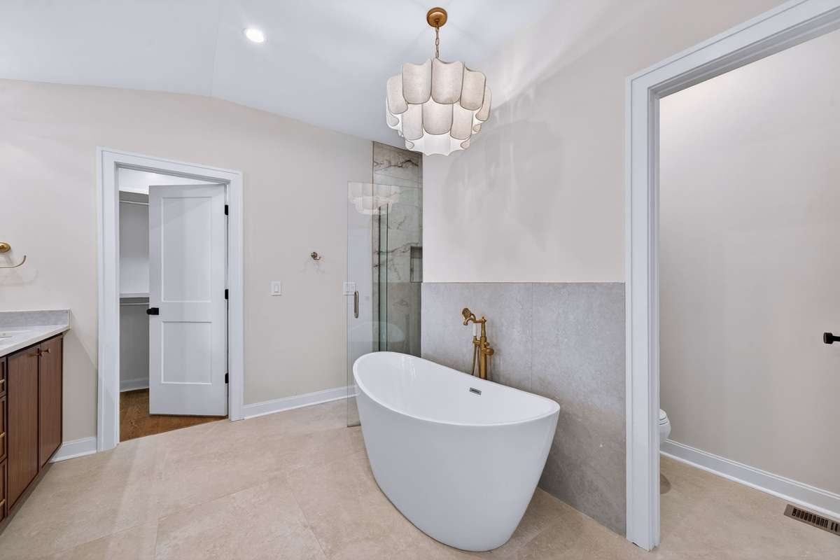 Unwind in the separate soaking tub, highlighted by the upscale chandelier.