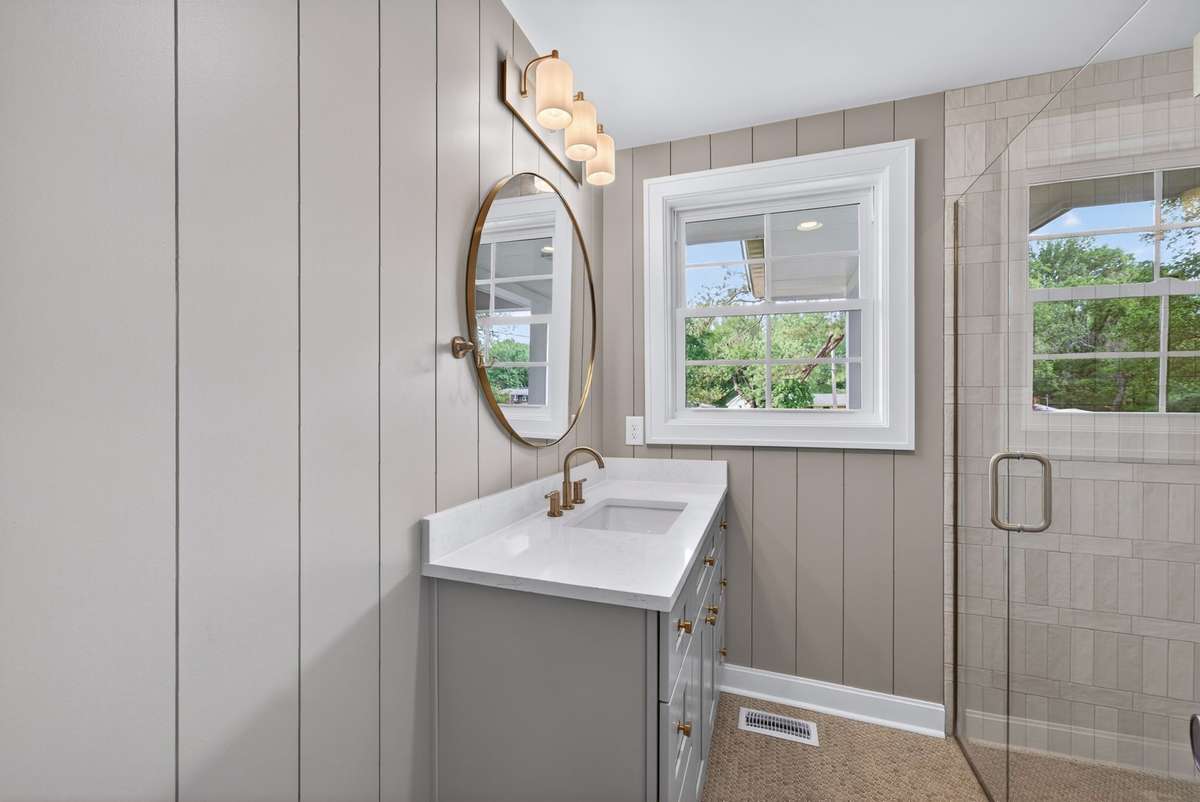 The hall bath features a large vanity with a zero-entry tiled shower.