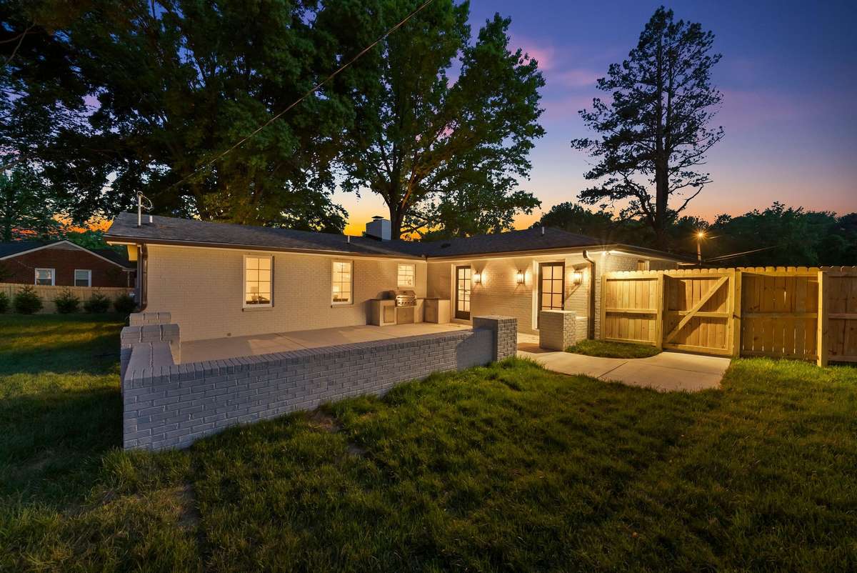 The home features a large patio and built-in outdoor kitchen with a grill.