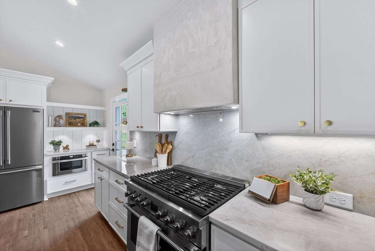 An elevated feature of the kitchen is the ArcusStone hood above the gas range.