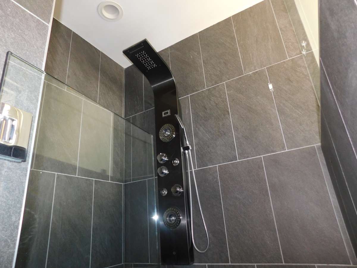 Stand up shower with Ceramic tile to the ceiling.