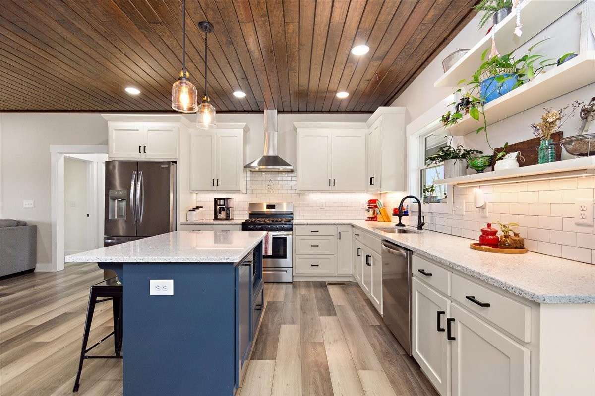 Here is your kitchen with nice cabinets, an island, a nice backsplash, and beautiful granite countertops.