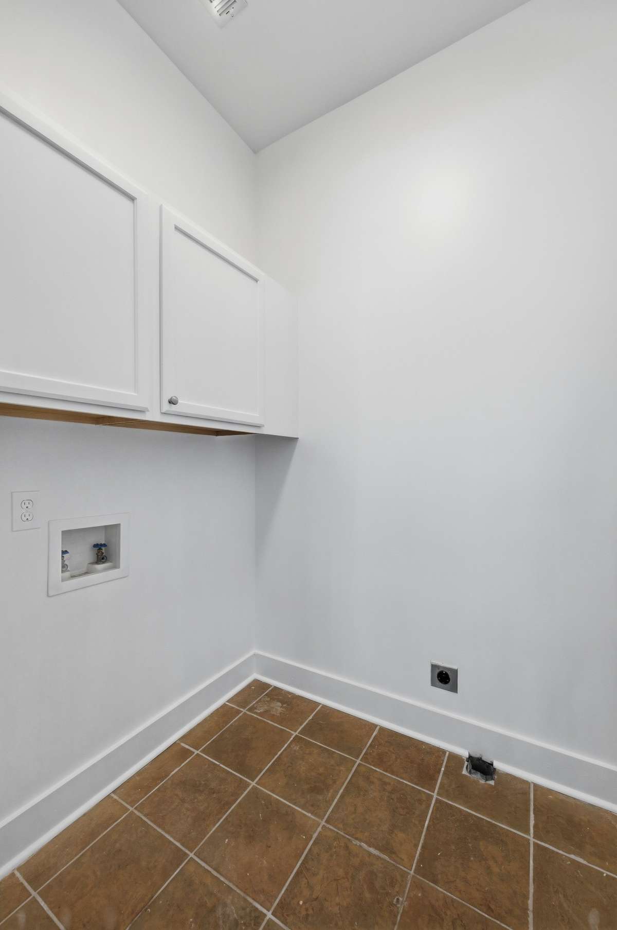 The laundry room is conveniently located on the second floor between the two upstairs bedrooms. It has a tile floor as well as cabinet storage.