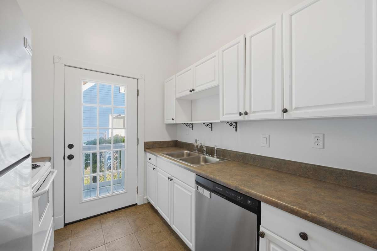 The door in the kitchen opens to a small landing with access to the side yard of the property, and also provides great natural light in this space as well.