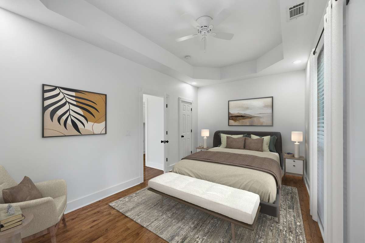The secondary bedroom upstairs is large and also has a tray ceiling and ceiling fan. The far door opens to a closet. Virtually staged.