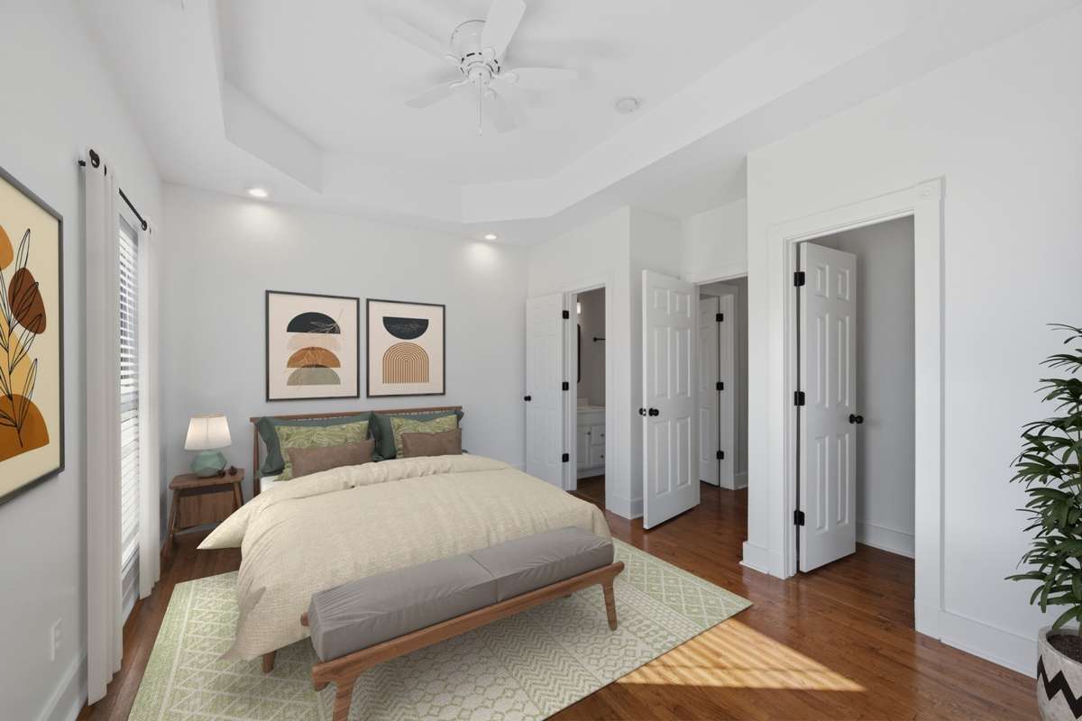 Another view of the primary bedroom. The far door leads to a full bathroom and the door on the right leads to a large walk-in closet. Virtually staged.