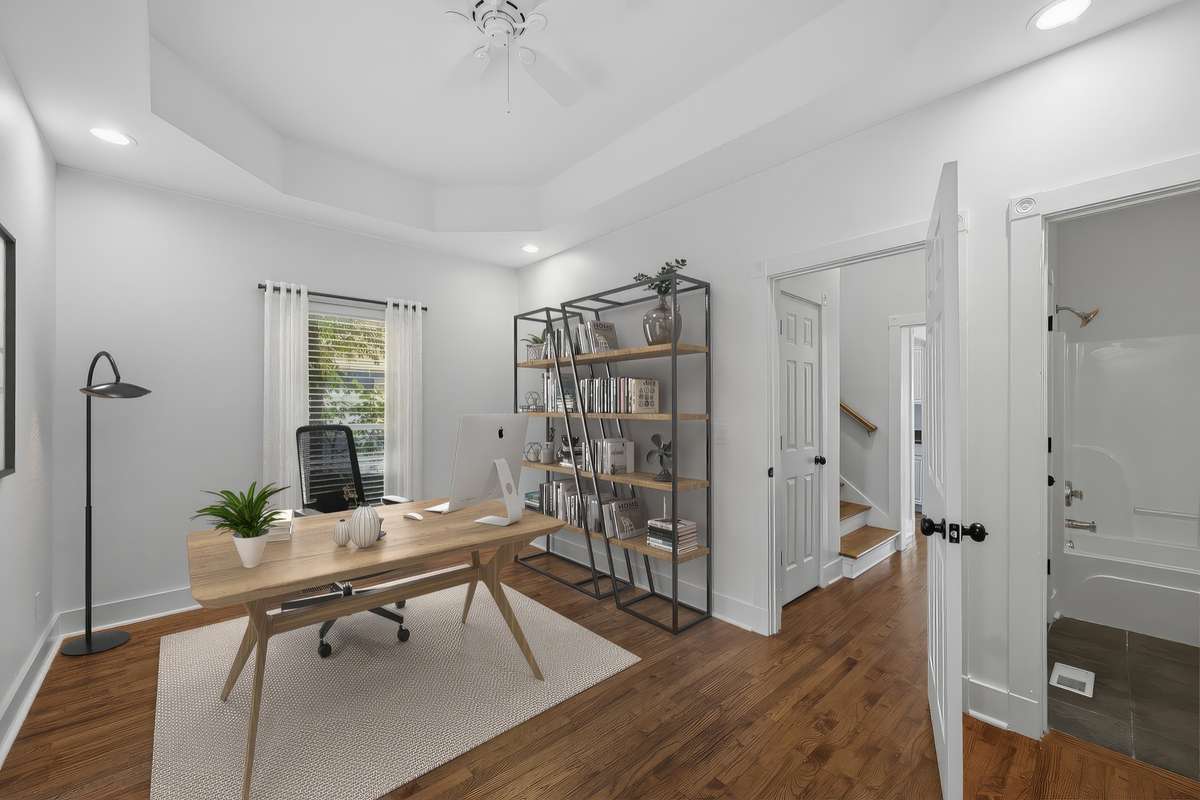 This bedroom on the main floor could also be used as an office or some other kind of flex space; there are two closets out of frame to the right, as well as direct access to the full bathroom. Virtually staged.