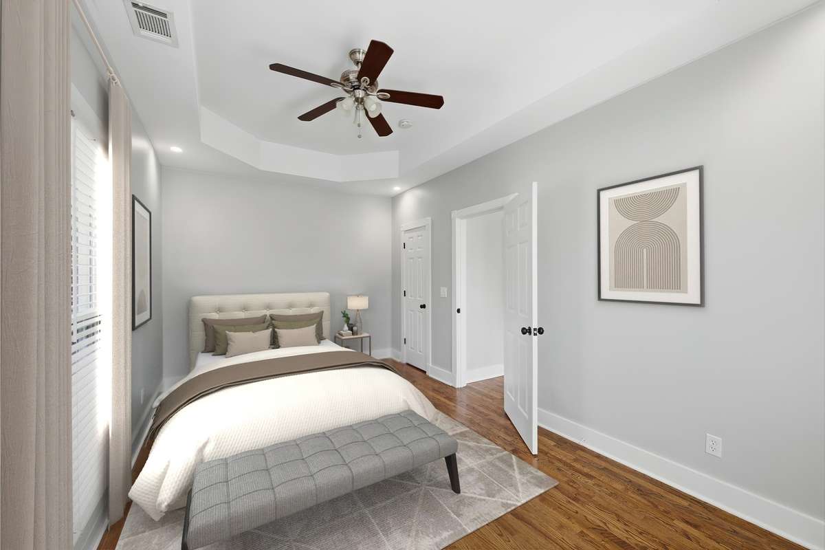 The secondary bedroom upstairs is large and also has a tray ceiling and ceiling fan. The far door opens to a closet. Virtually staged.