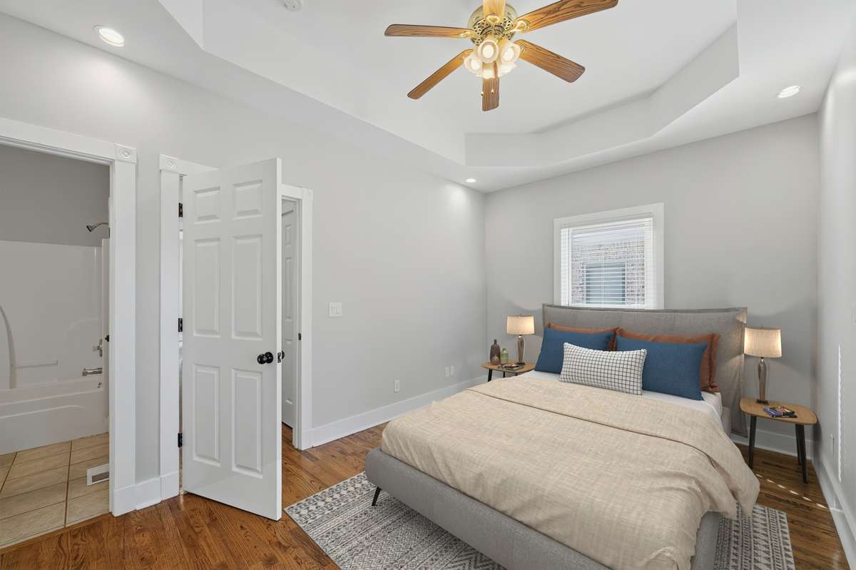 This bedroom on the main floor could also be used as an office or some other kind of flex space; there are two closets out of frame to the left, as well as direct access to the full bathroom. Virtually staged.