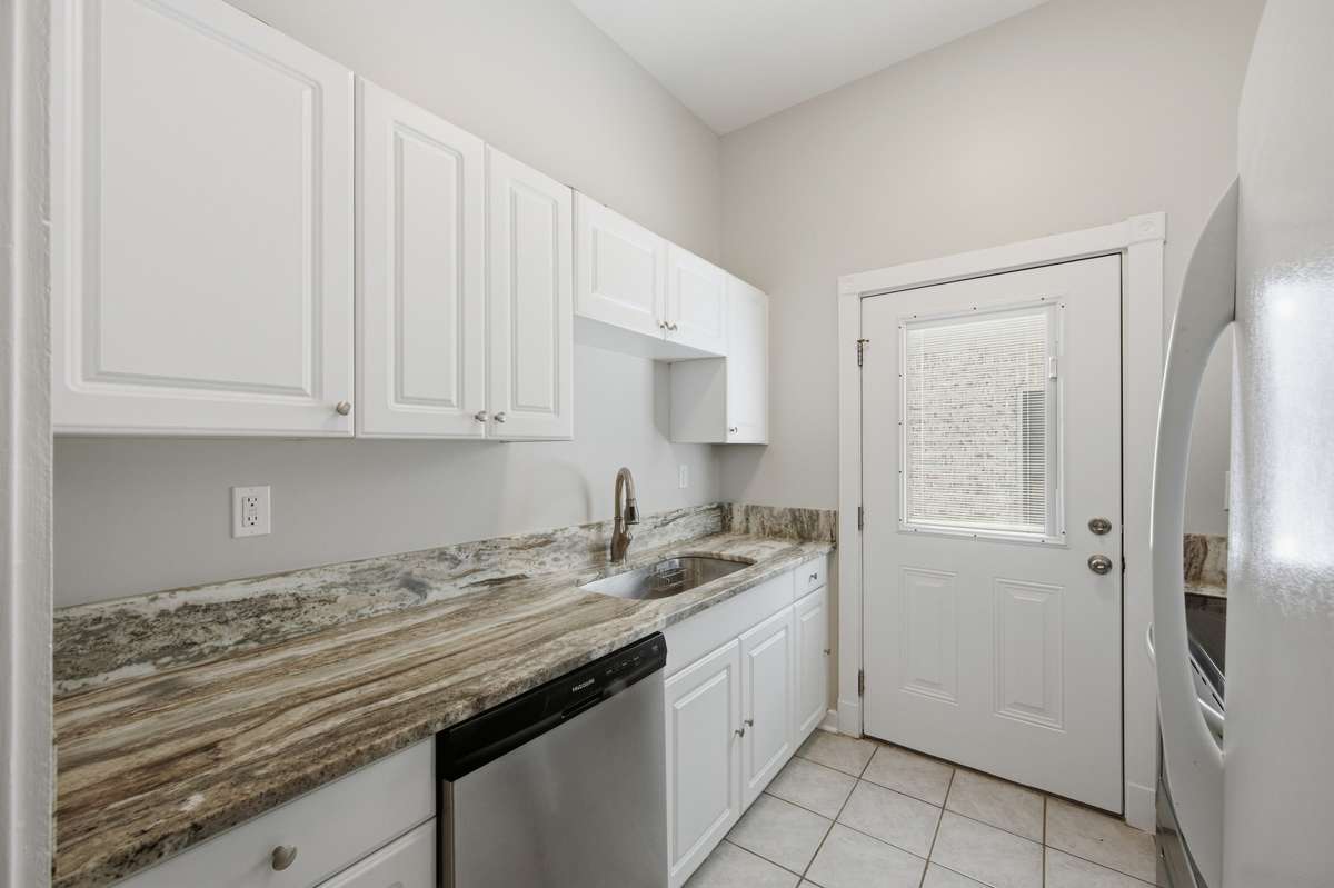 The door in the kitchen opens to a small landing with access to the side yard of the property, and also provides great natural light in this space as well.