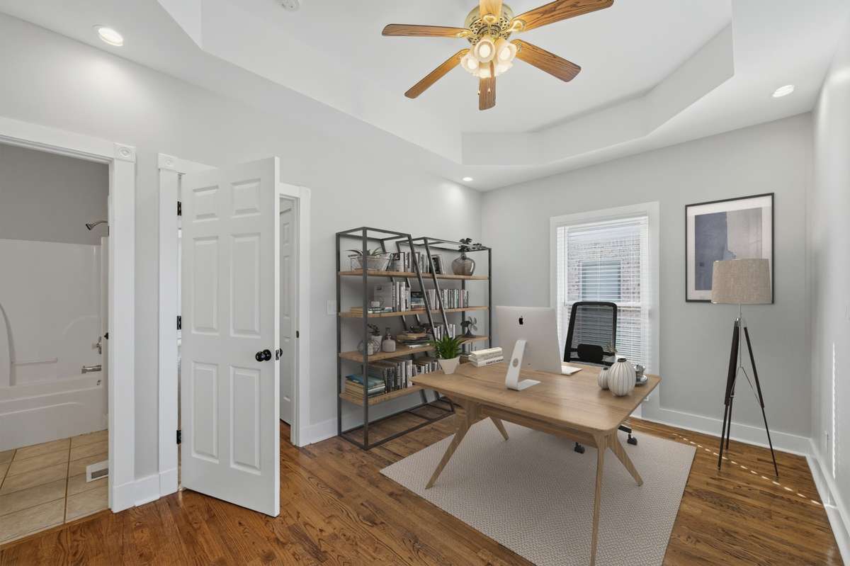 This bedroom on the main floor could also be used as an office or some other kind of flex space; there are two closets out of frame to the left, as well as direct access to the full bathroom. Virtually staged.