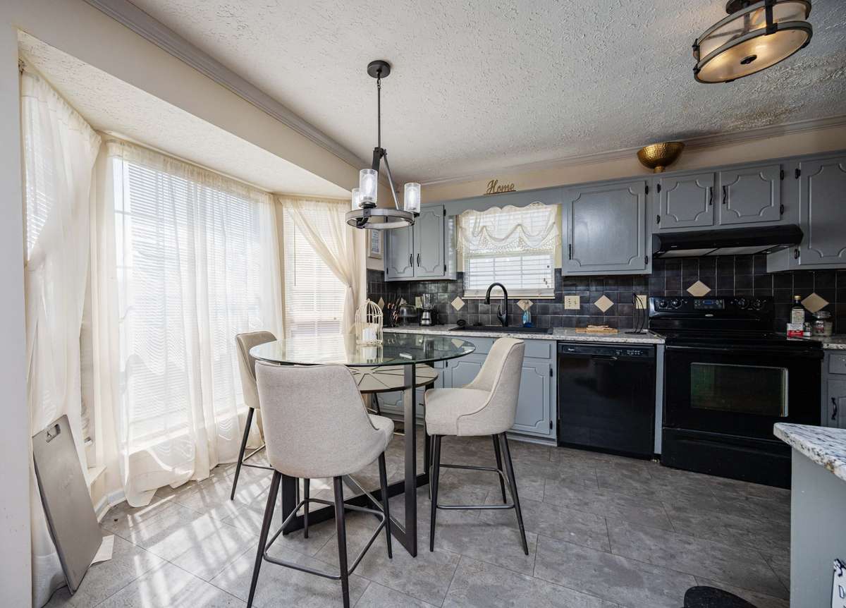 Kitchen has painted cabinets and pretty granite tops