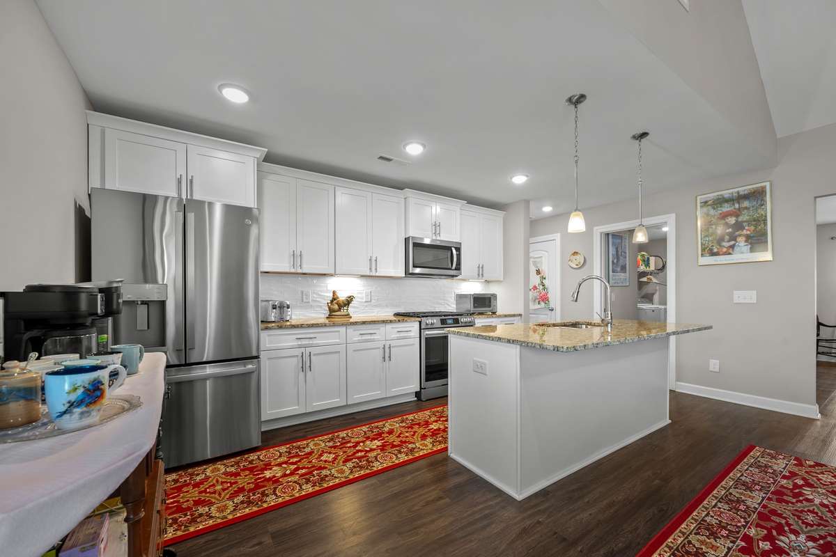 Kitchen with granite countertops, textured tile backsplash.