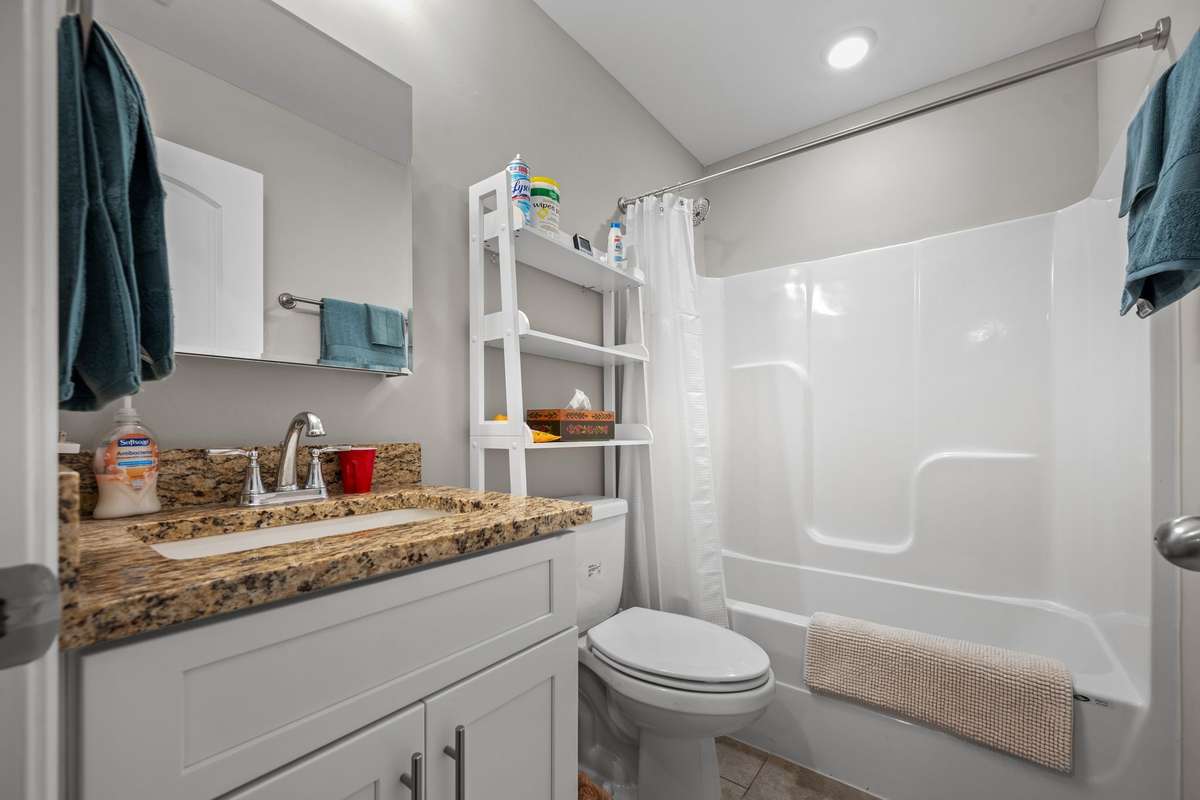Guest Bath has granite countertops and shower/tub combination.