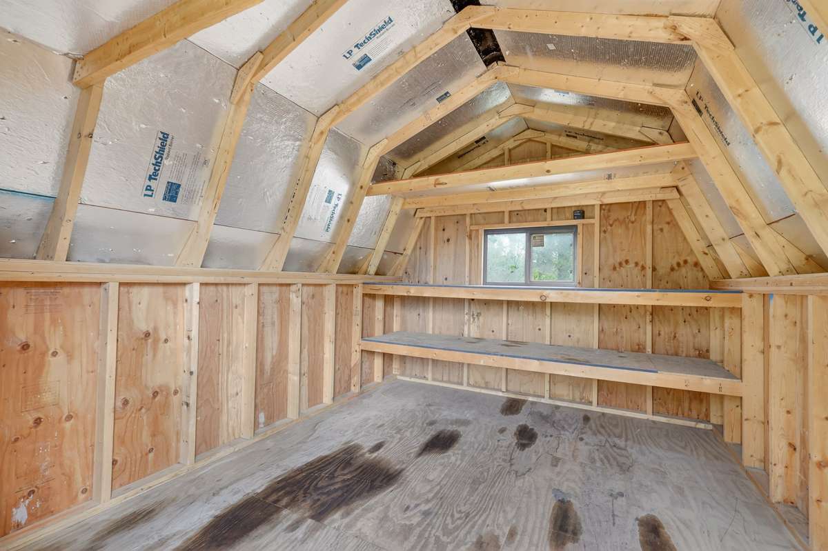 Inside the large red shed you will find plenty of storage with an additional level. Shed is partially insulated for extra protection