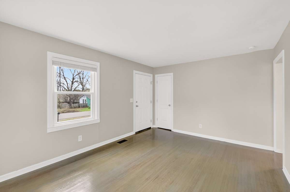 Another angle of the living room to entrance door. Has a small coat closet as well