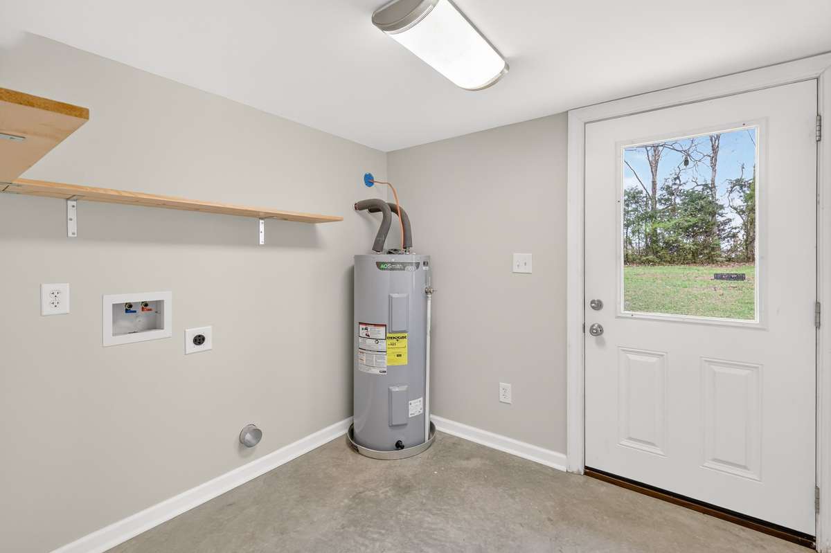 Entering into back door you find the laundry connections and water heater. This space is perfect for taking off shoes and hanging up coats before entering the main home