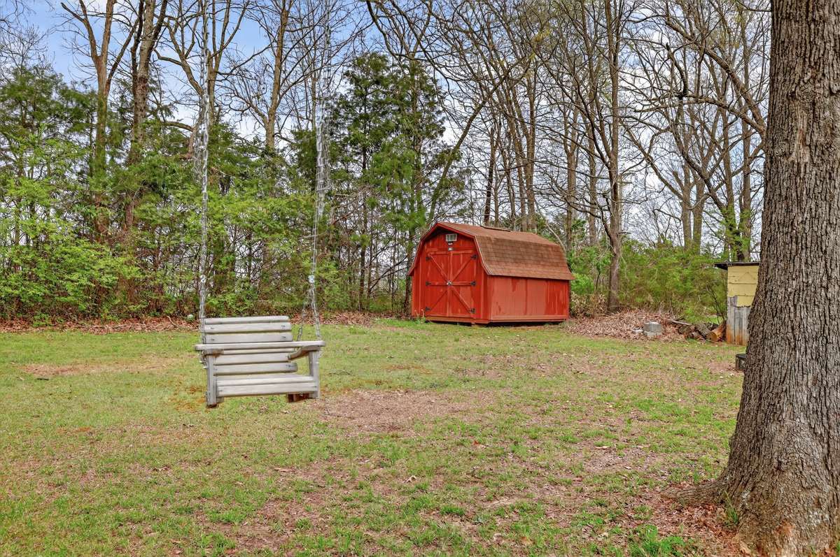 Another view of backyard with a cute swing
