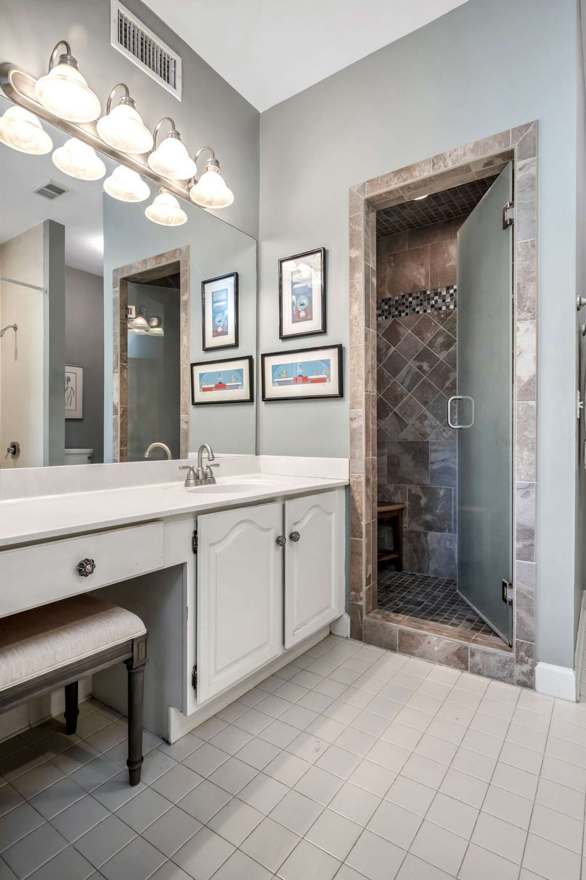 Primary ensuite bathroom offering a walk in shower & a shower/tub combo.