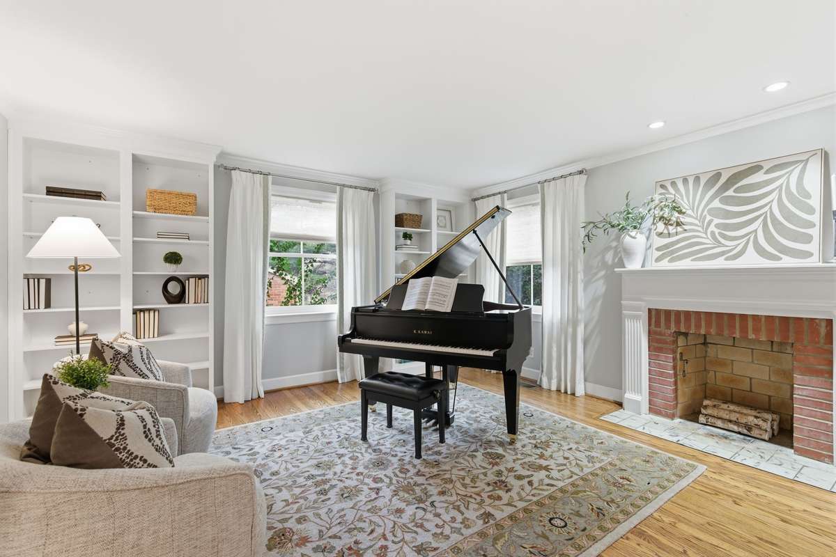 Formal living room with built-in bookshelves and charming fireplace.