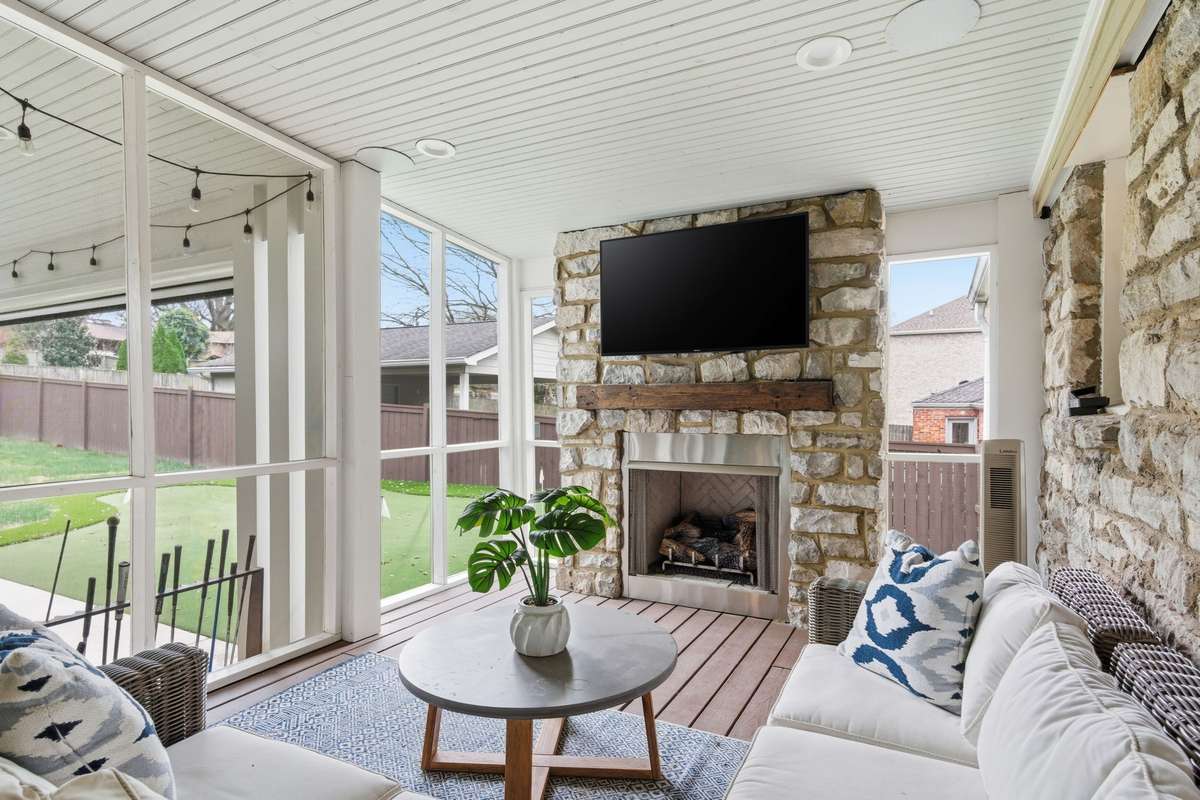 Screened porch with gas fireplace overlooking the private putting green.