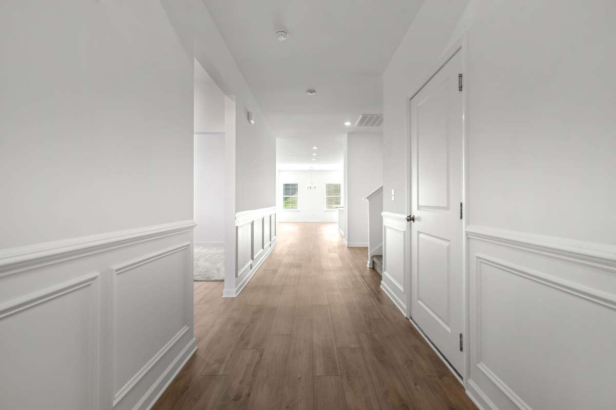This wide hallway has such a bright, welcoming feel — the kind of entry that instantly sets the tone for the rest of the home. The clean wainscoting, warm flooring, and soft natural light are a great first look as you step inside.