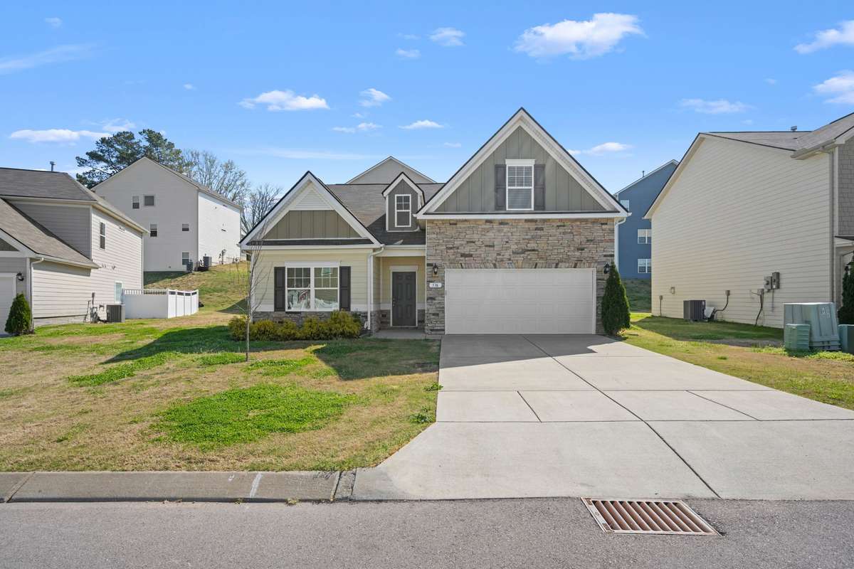A charming mix of stone and siding, welcoming front porch, and beautifully balanced gables. The clean lines, fresh exterior, give that good impression even before you step inside.