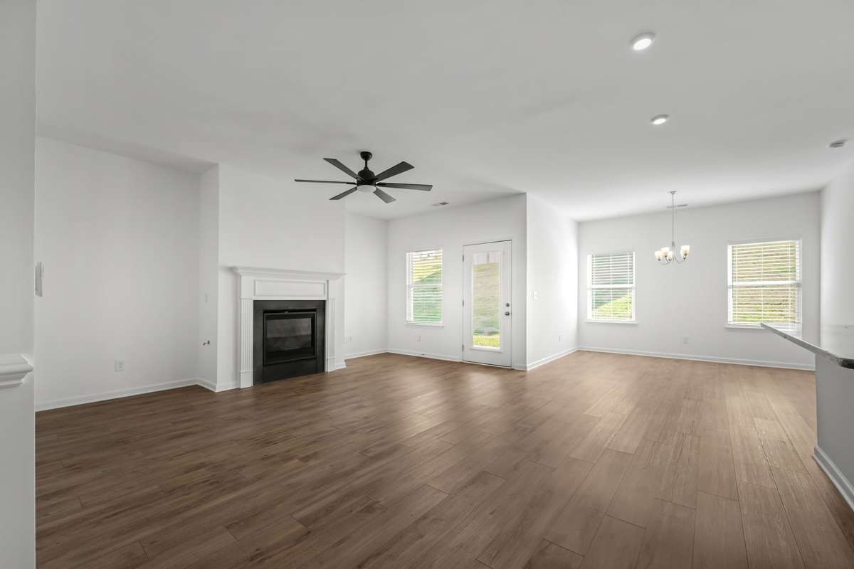 This bright family room with gas fireplace, opens into the large island and kitchen, creating an open, welcoming space perfect for everyday living and easy entertaining. Warm floors, natural light, and a modern layout make it the heart of the home.