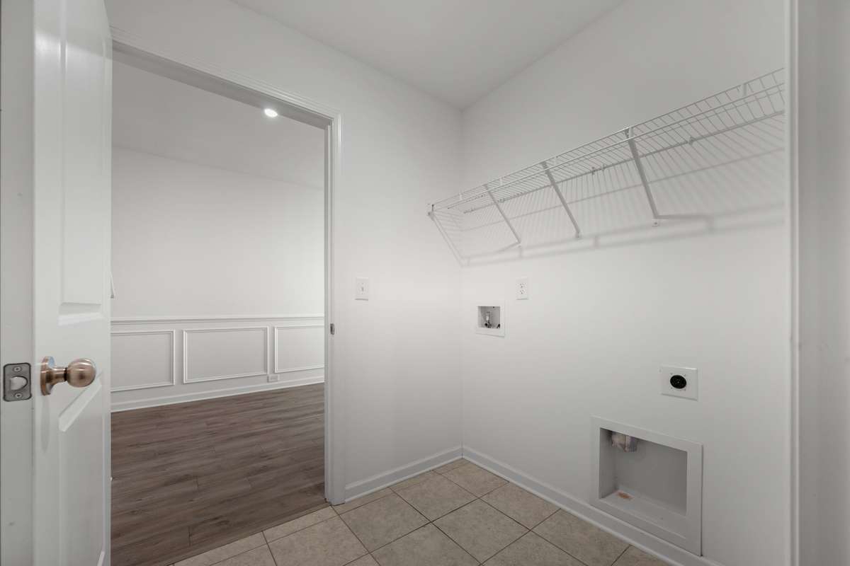 The spacious laundry room opens into the hallway on one side, while another door opens into the large master closet.