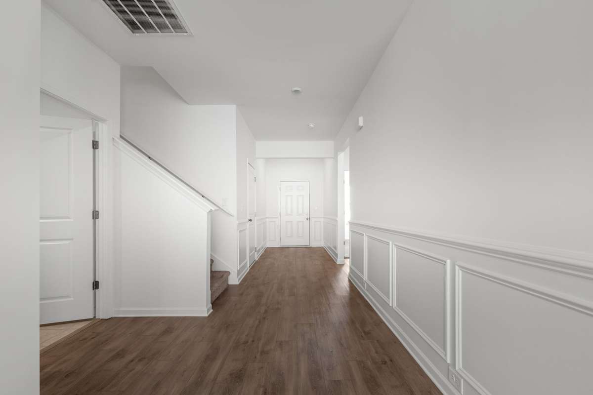 Looking at the front door from the other end of the entryway/hallway. Lots of space to place a table and lamp, along with a wall of family photos!