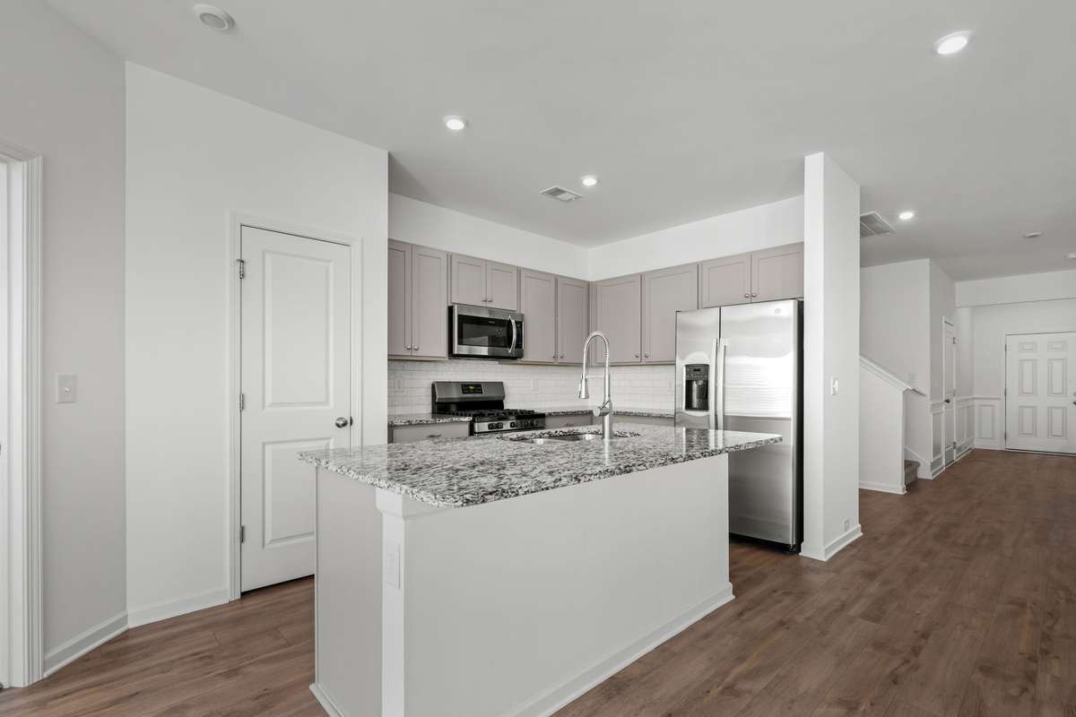With all the windows, the light and bright kitchen is inviting, yet feels warm and cosy with the soft grey cabinets and stainless steel appliances.