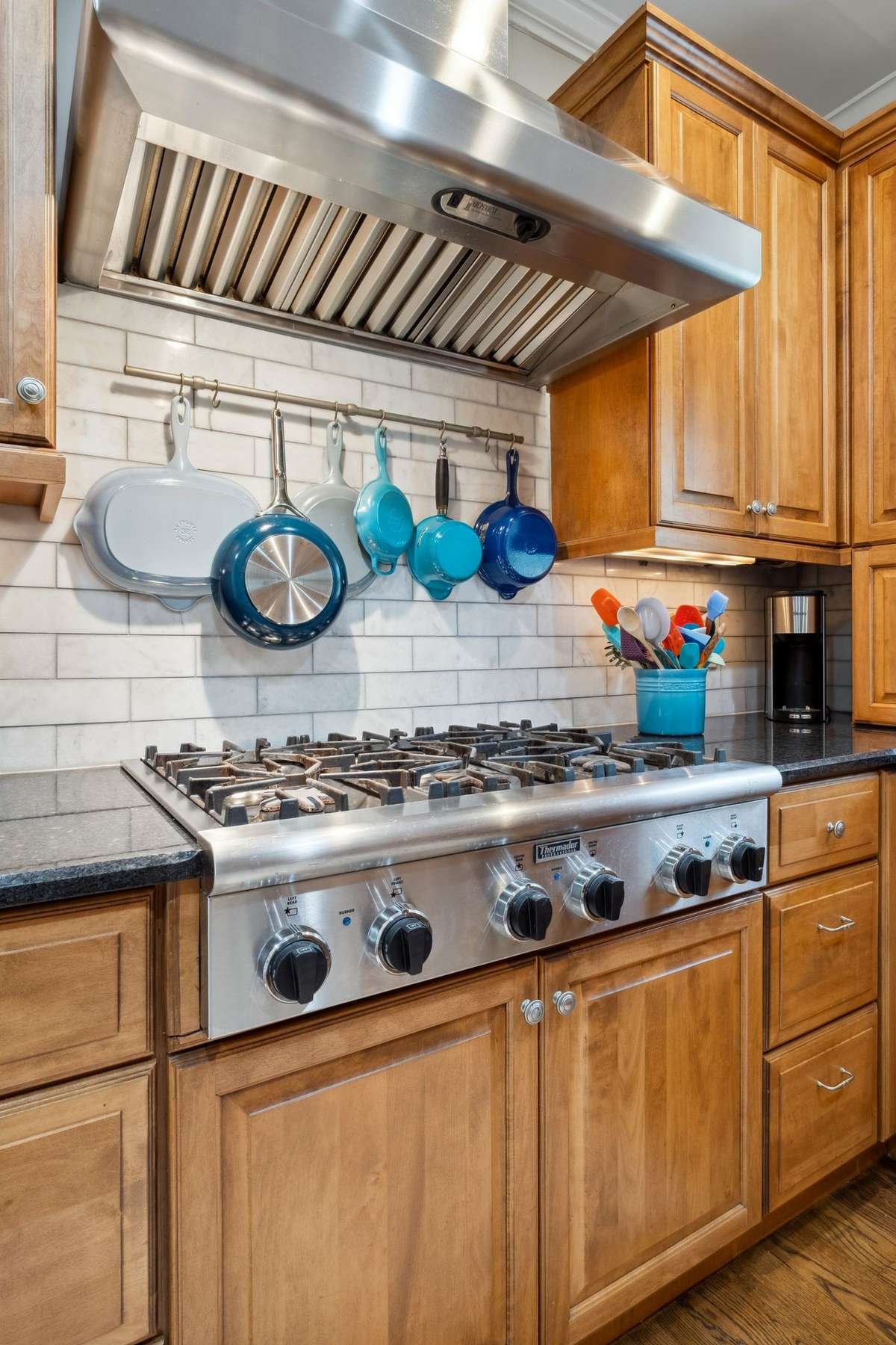 You will appreciate the Thermador 6 burner gas cooktop and stainless vent hood. The rack over the cooktop provides convenient storage for pots, pans and utensils.