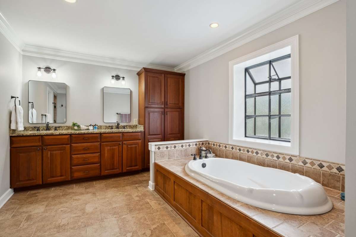 The large primary bath has ample room to get ready in morning and store all the essentials with a walk-in closet, double granite topped vanity and linen tower.