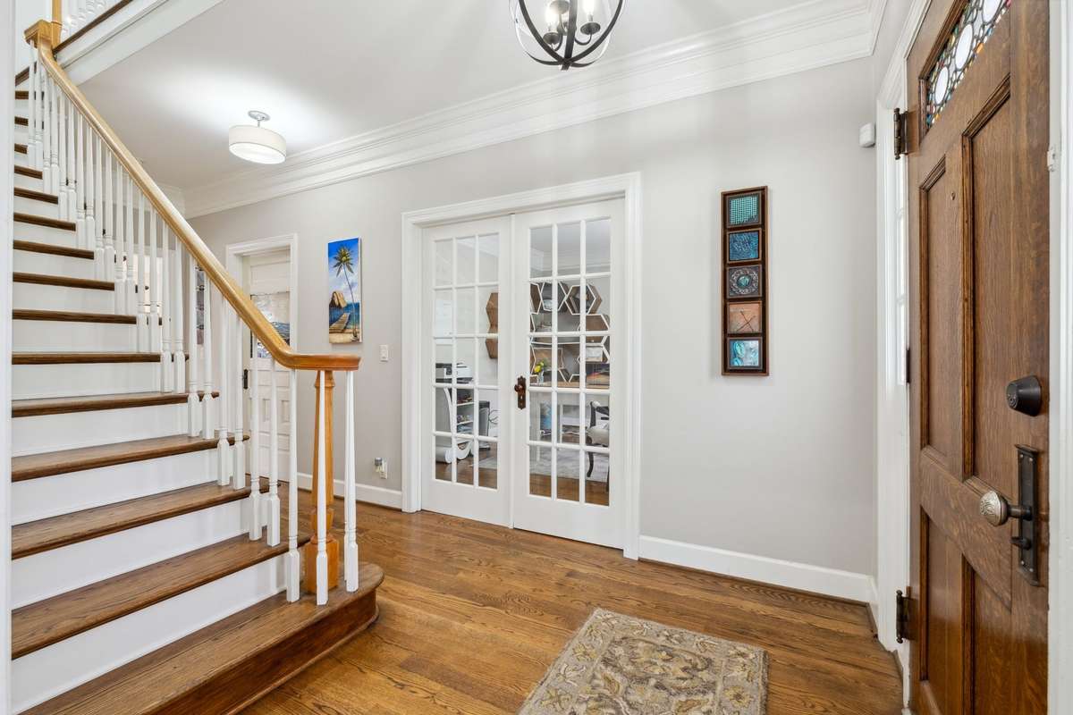 Glistening hardwood floors flow throughout the home. The French doors open into a private office. Down the hall is a coat closet, powder room and laundry room.