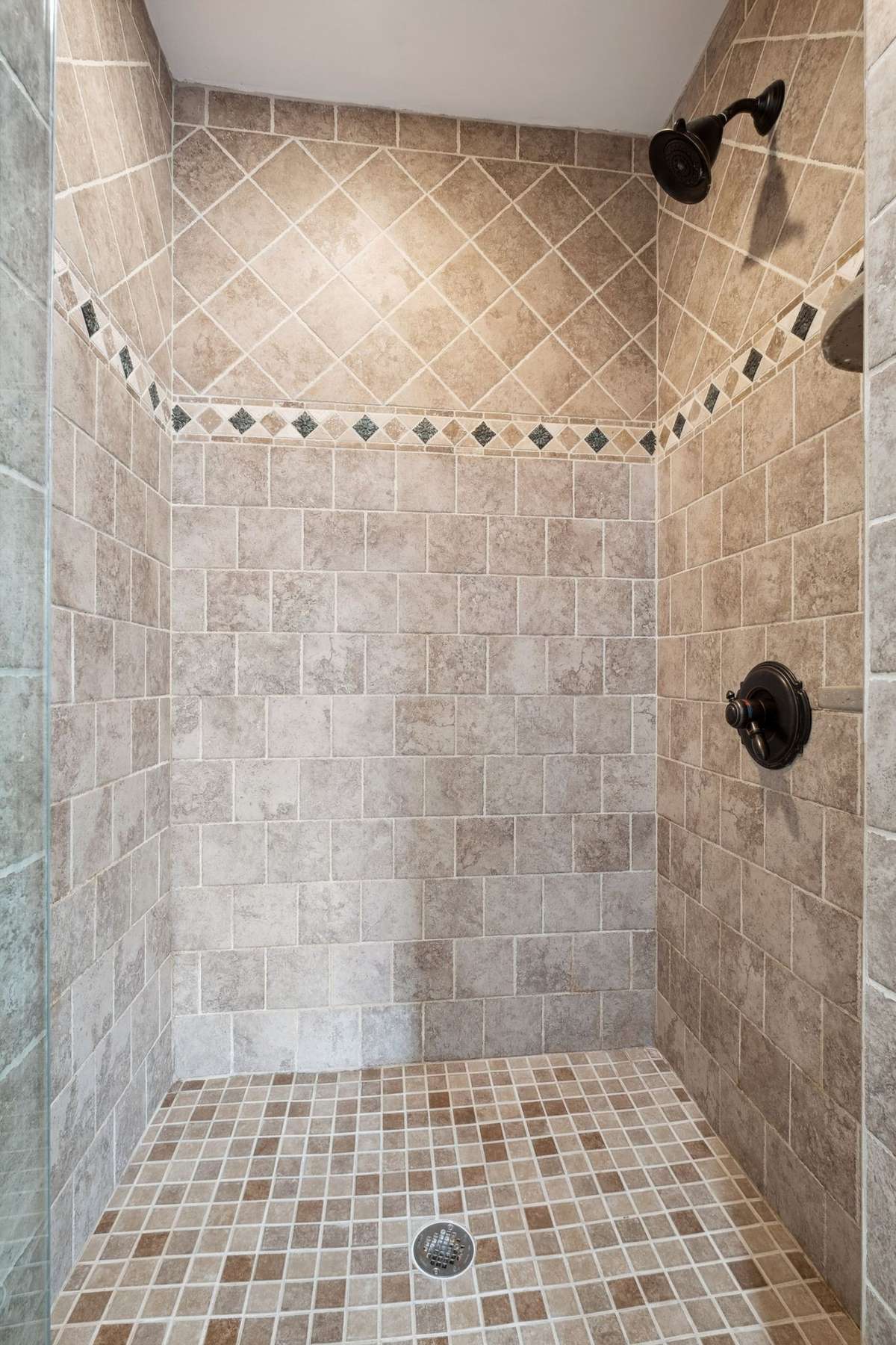 The primary bath has a separate ceramic tiled shower with a frameless glass door and a private water closet.