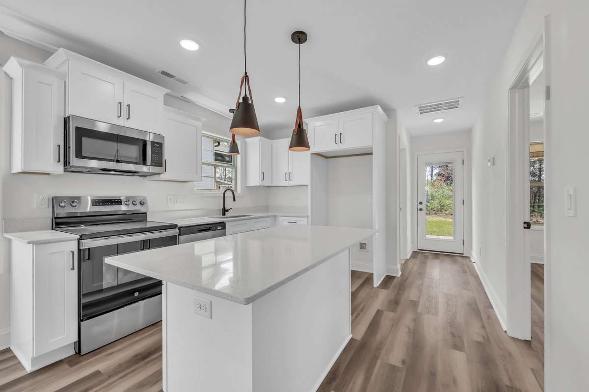 Gorgeous kitchen with white cabinets, granite counters and stainless steel appliances