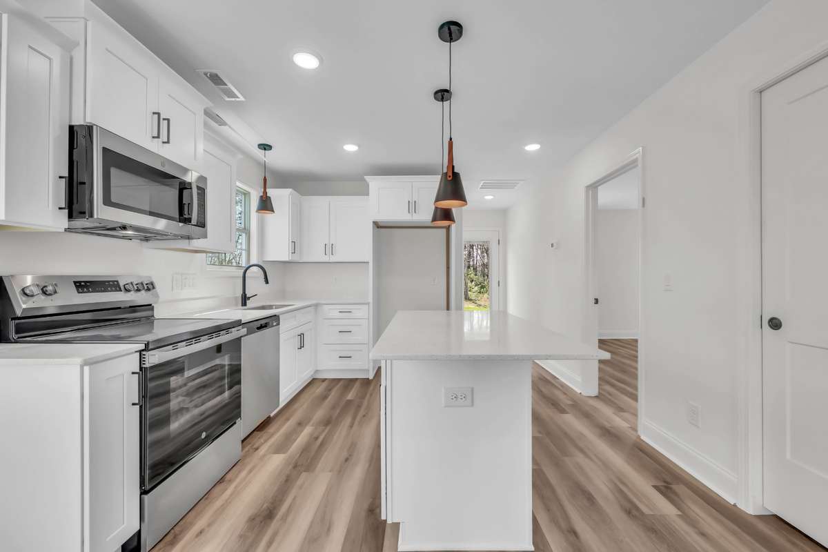 Gorgeous kitchen with white cabinets, granite counters and stainless steel appliances