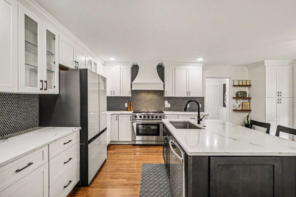 Check out the completely redone kitchen with quartz counters, a large island and decorative vent hood