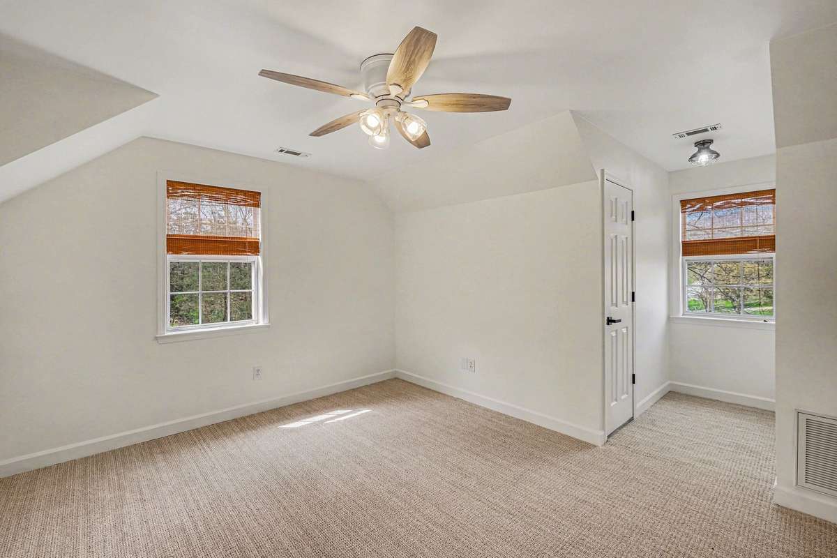 Two large bedrooms upstairs with lots of light and a brand new hvac unit of their own. Also  notice the new fans, new window treatments & new carpet. This room as attic storage through that door seen in the picture