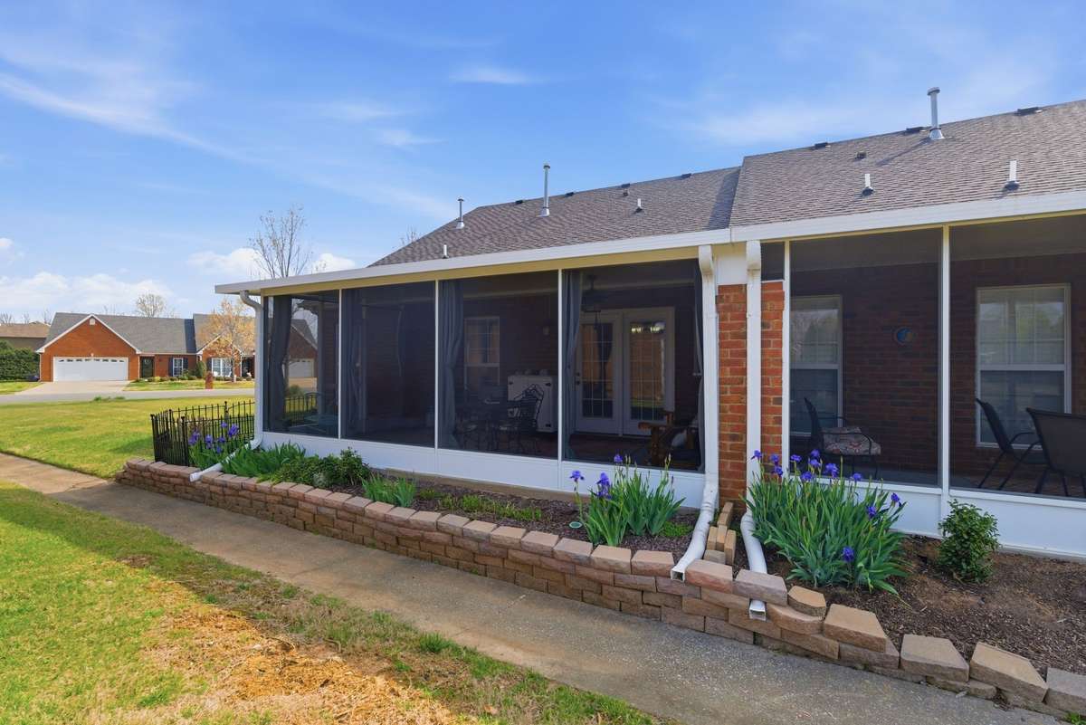 Covered porch is nicely landscaped, huge side yard