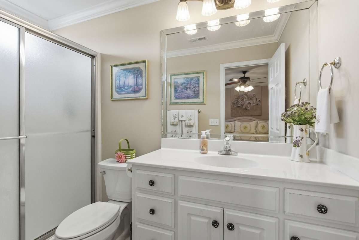 Primary bath has White Cabinets and walk in shower