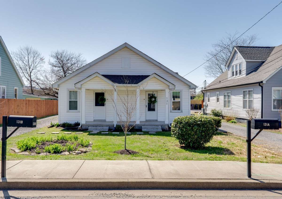 Front garden, shared porch, storm doors, and windows [replaced in 2021]. Photo from 2021.