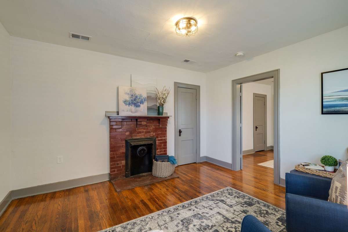 Unit A: The living room features a faux fireplace, coat closet and access to the bedroom. Photo from 2021.