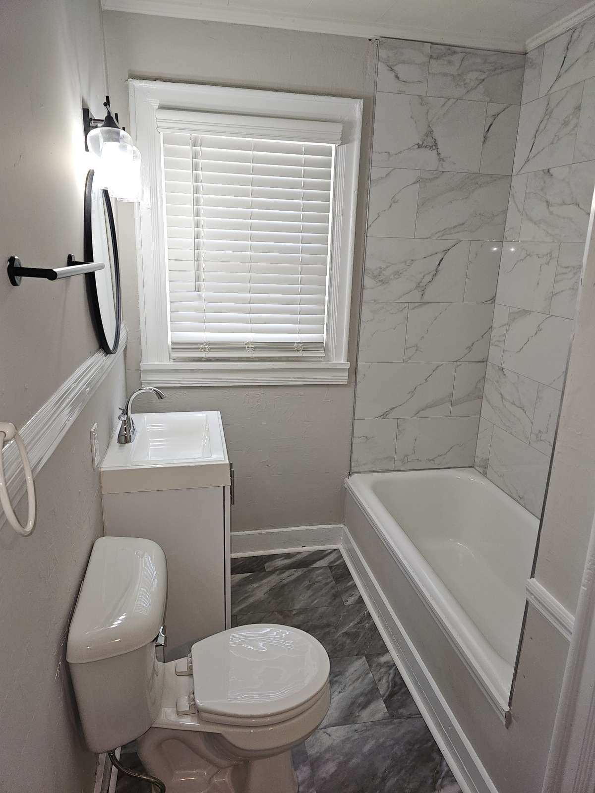 Unit B bathroom updated with new tile shower surround and new flooring in 2025.