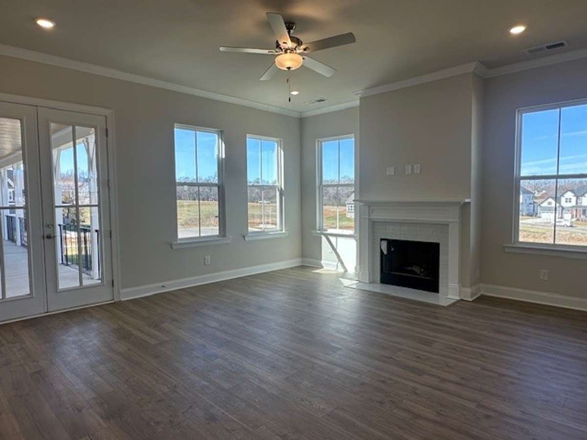 Your Great Room features 10' ceilings, lots of natural light, cheery wood burning fireplace with gas starter and tile surround, and 8' french doors leading out to the side porch/breezeway!