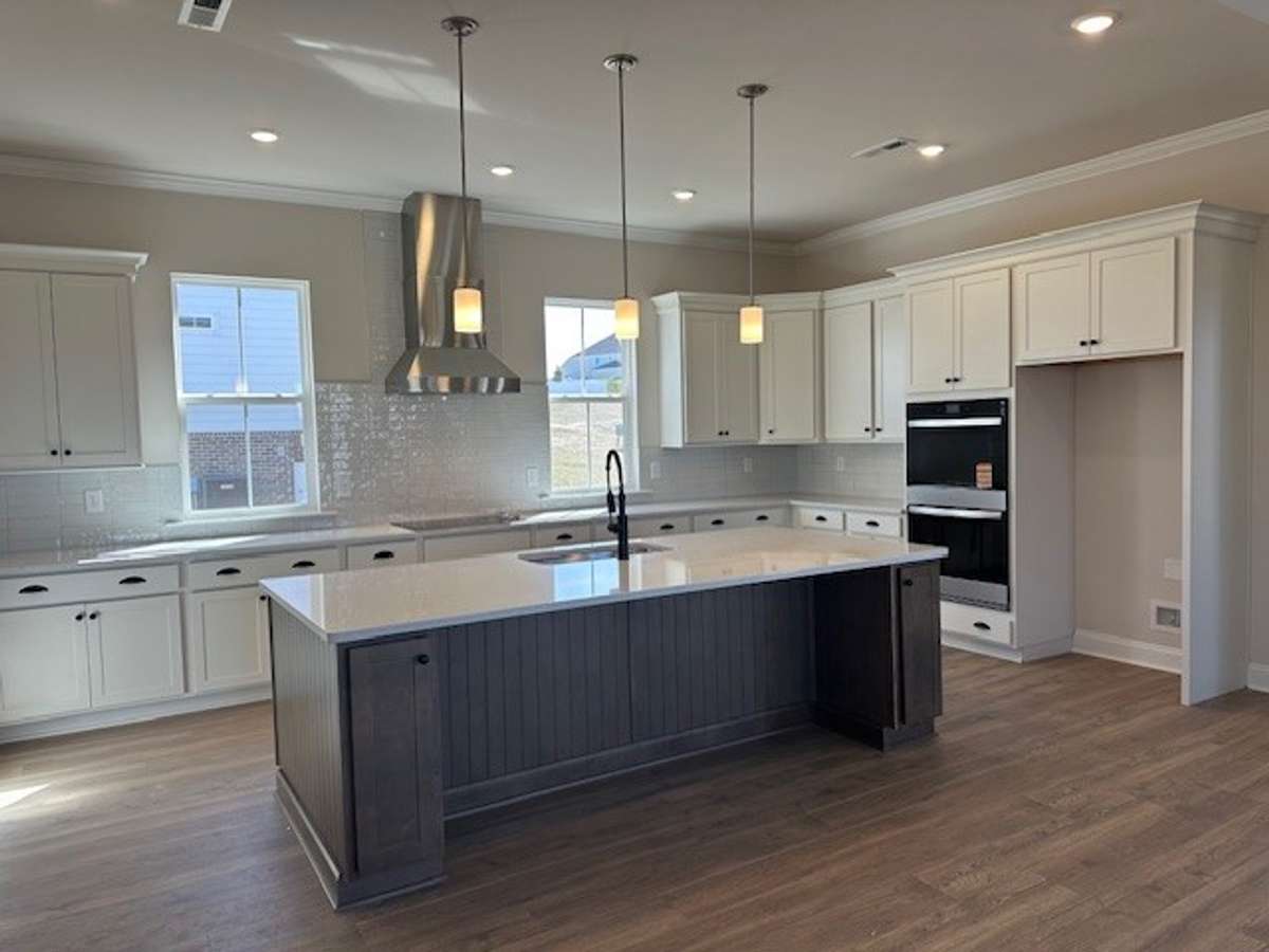Let's talk about this! Upgraded cabinets, built in double ovens, microwave built in to the back of your HUGE island, gleaming quartz countertops, modern tile backsplash, stainless steel vent hood and an abundance of lighting!