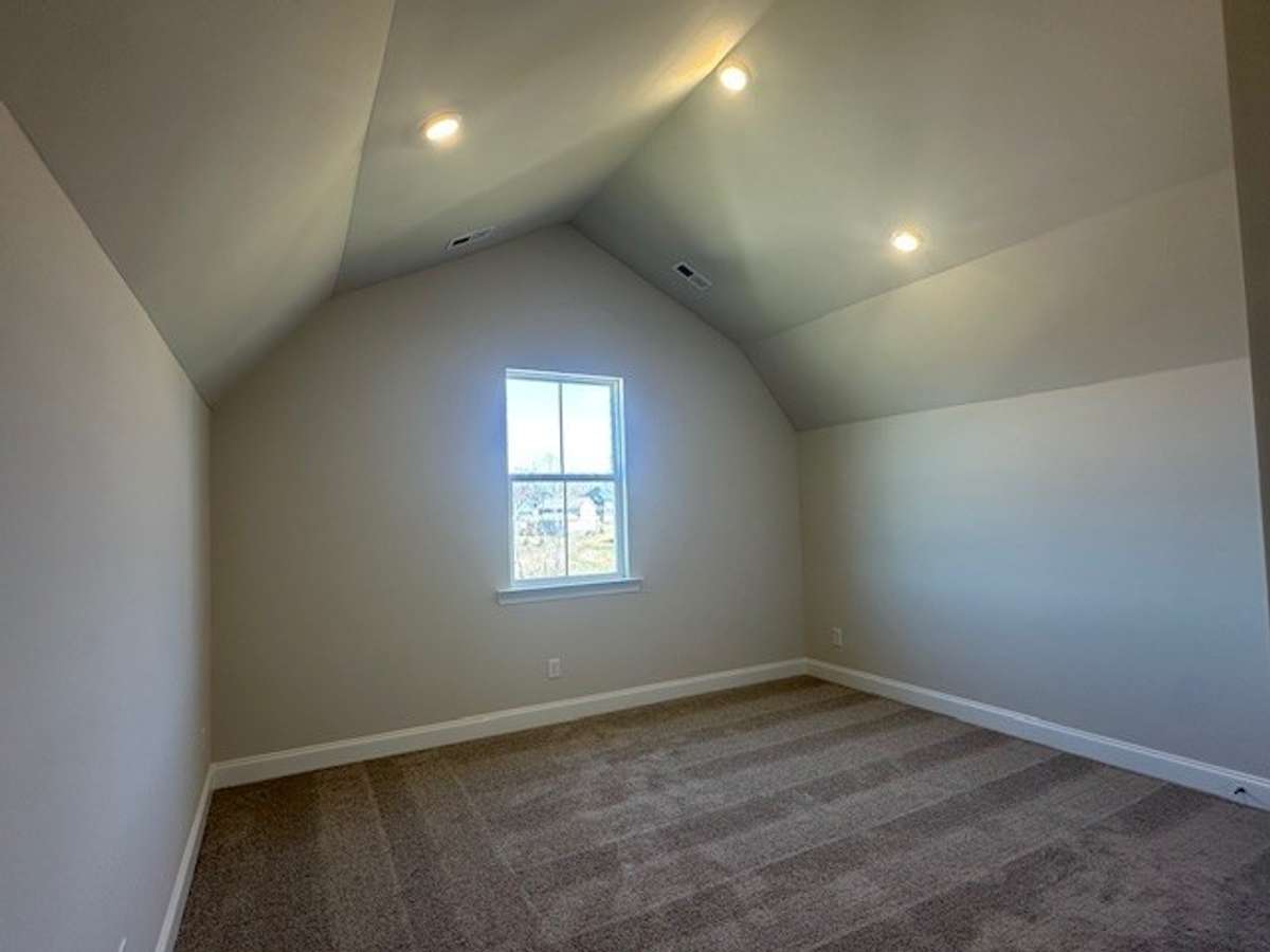 Upstairs Bedroom retreat features a fun ceiling vault, great lighting, and a full bath!