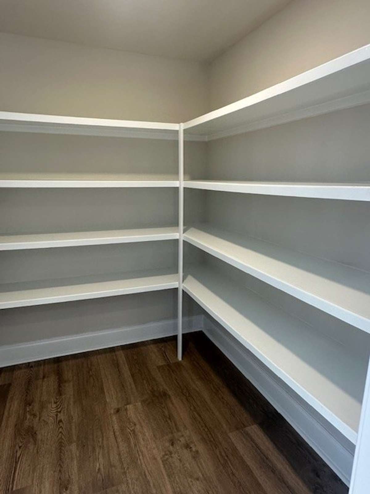 Customized wood shelving in this spacious walk in Kitchen Pantry gives you space for all the things!