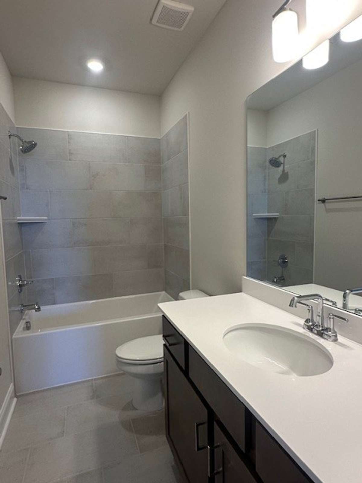 Upstairs Bath is off the bonus room with a door accessing the bedroom, and showcases a beautiful tile surround!